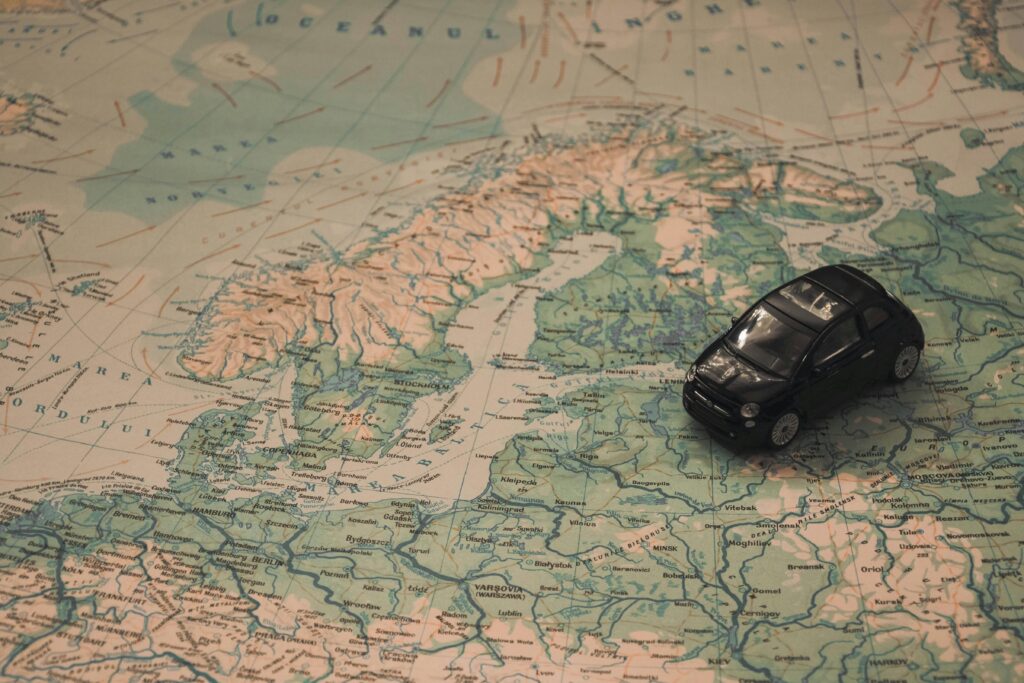 A miniature black car on a detailed map of Scandinavia, symbolizing travel adventures.